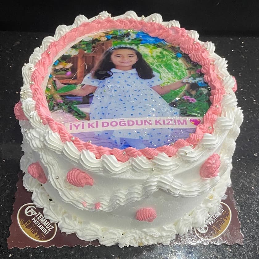 Üzerinde kız çocuğu fotoğrafı olan pembe bordürlü pasta