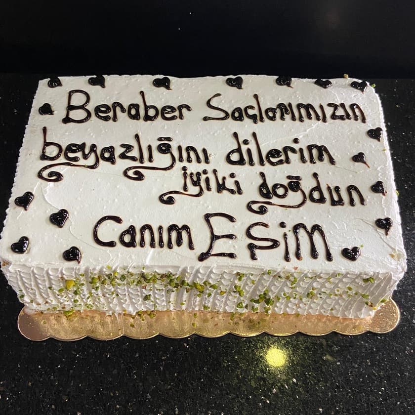 Çikolata yazılı, kenarı fıstıklı dikdörtgen beyaz pasta